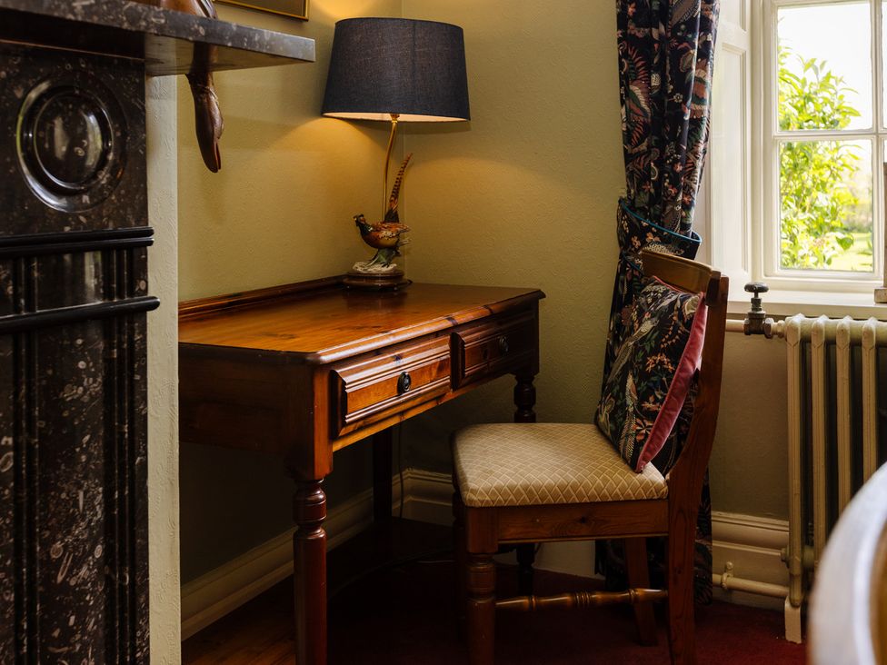 A study area with a desk and lamp at Cheviot Manor Akeld near Wooler