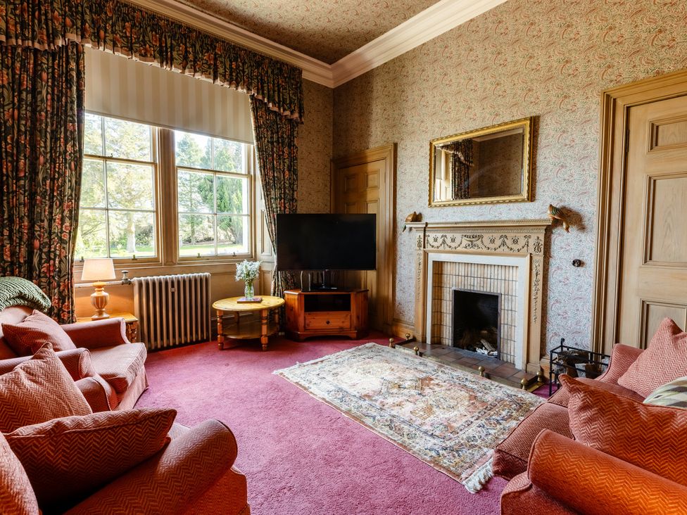 A living room with a sofa and television at Cheviot Manor in Akeld near Wooler