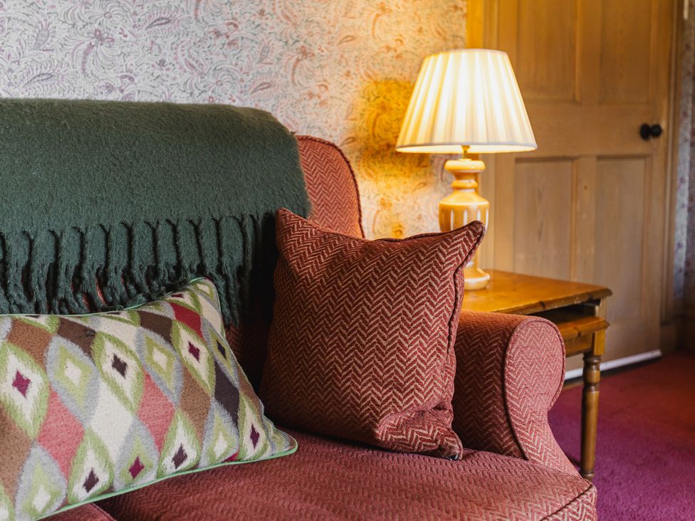 A living room with a sofa and a lamp at Cheviot Manor near Wooler