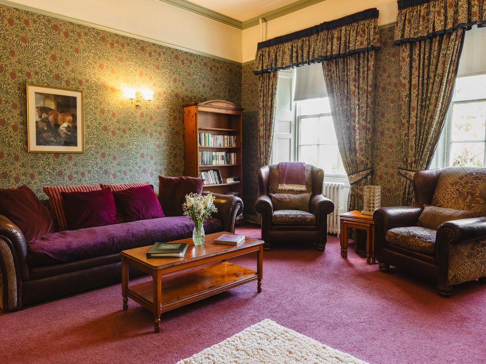 A living room with a coffee table and bookshelf at Cheviot Manor near Wooler