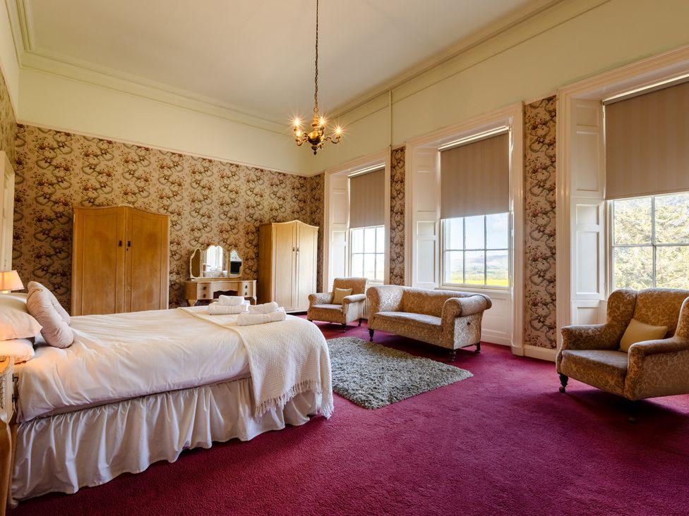 A bedroom with a bed and wardrobe at Cheviot Manor in Akeld near Wooler