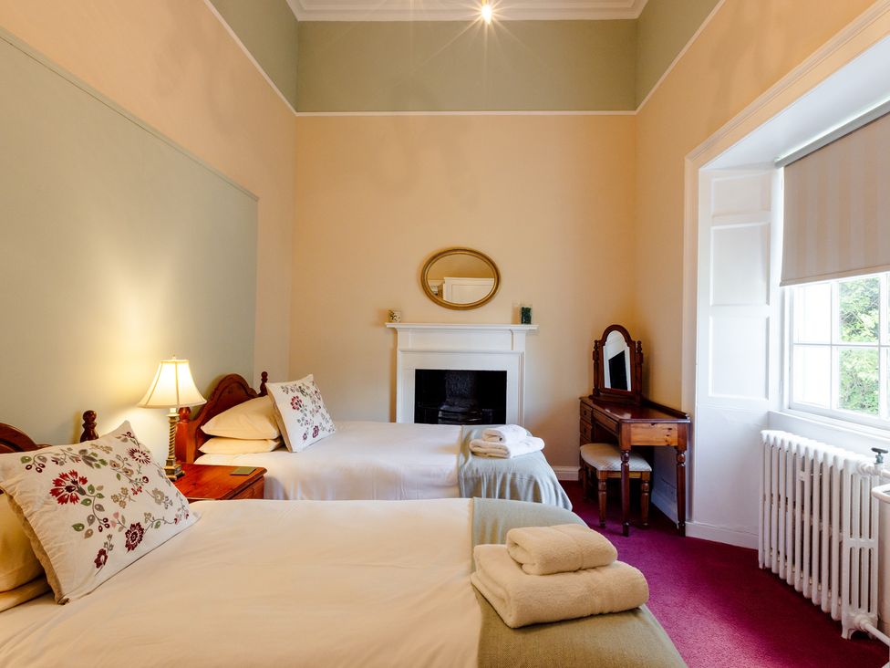 A bedroom with two beds and a fireplace at Cheviot Manor Akeld near Wooler