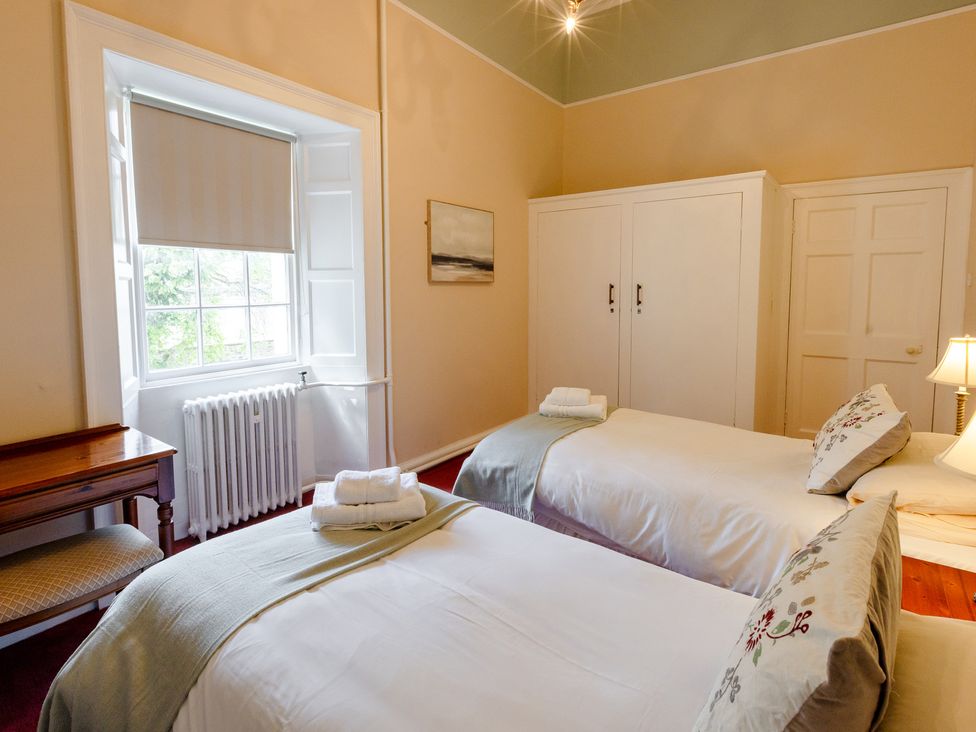 A bedroom with two beds and a window at Cheviot Manor in Akeld near Wooler