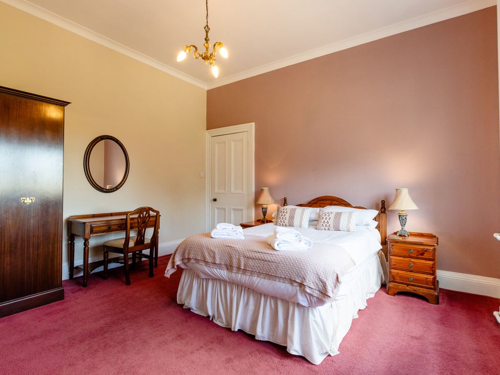 A bedroom with a bed and wardrobe at Cheviot Manor Akeld near Wooler