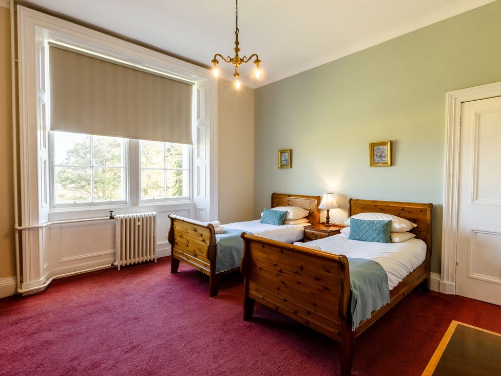 A bedroom with two beds and a window at Cheviot Manor Akeld near Wooler