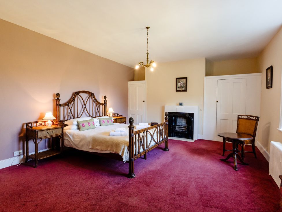 A bedroom with a bed and a chair at Cheviot Manor Akeld near Wooler