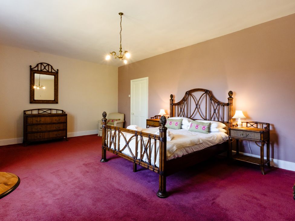 A bedroom with a bed and nightstands at Cheviot Manor in Akeld near Wooler