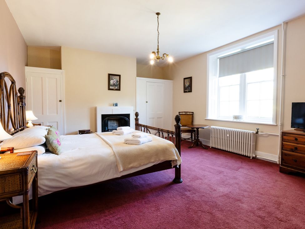 A bedroom with a bed and chair at Cheviot Manor in Akeld near Wooler