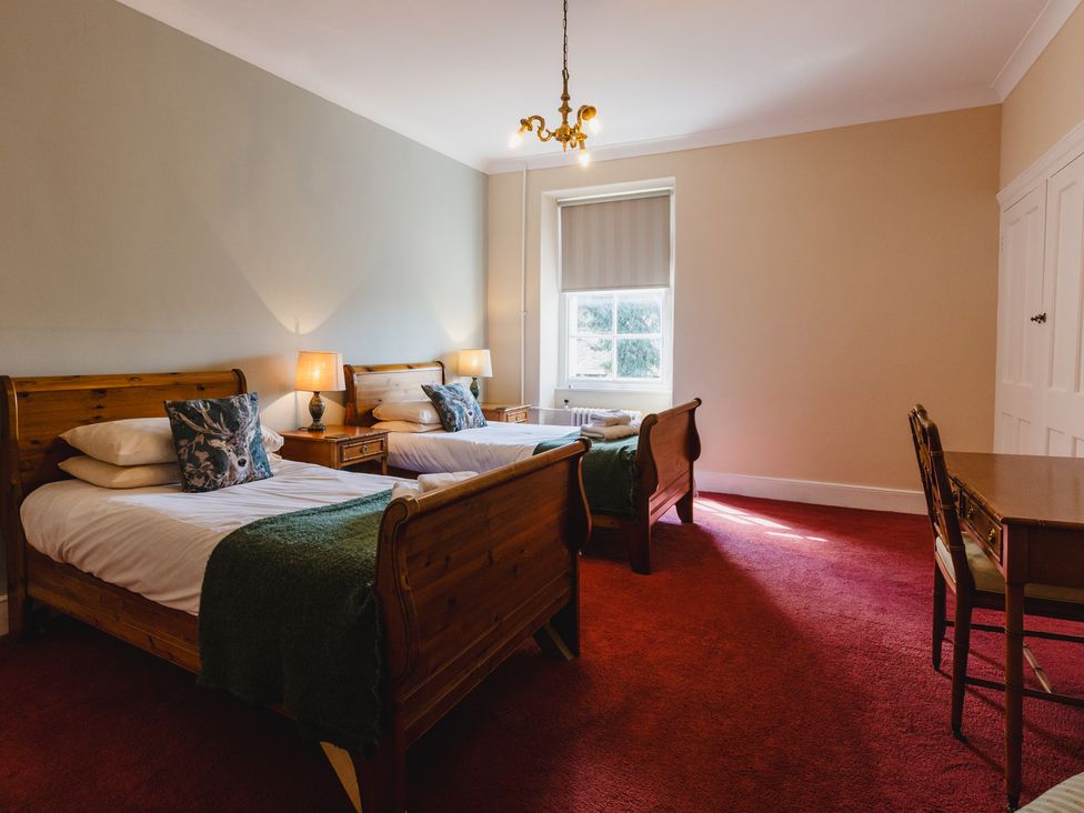 A bedroom with two beds and a desk at Cheviot Manor in Akeld near Wooler