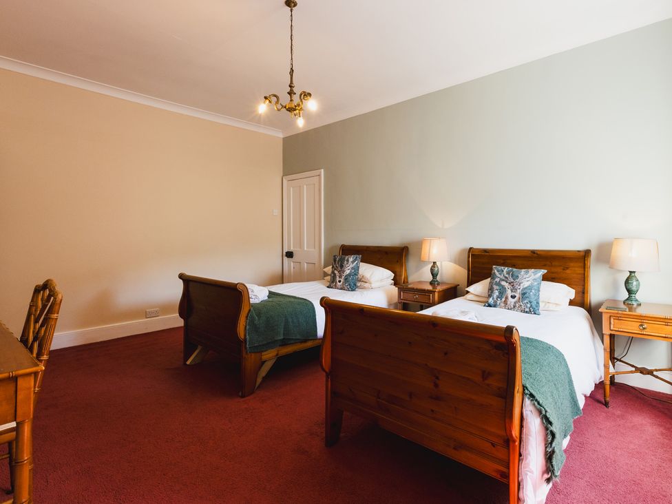 A bedroom with two beds and a desk at Cheviot Manor Akeld near Wooler