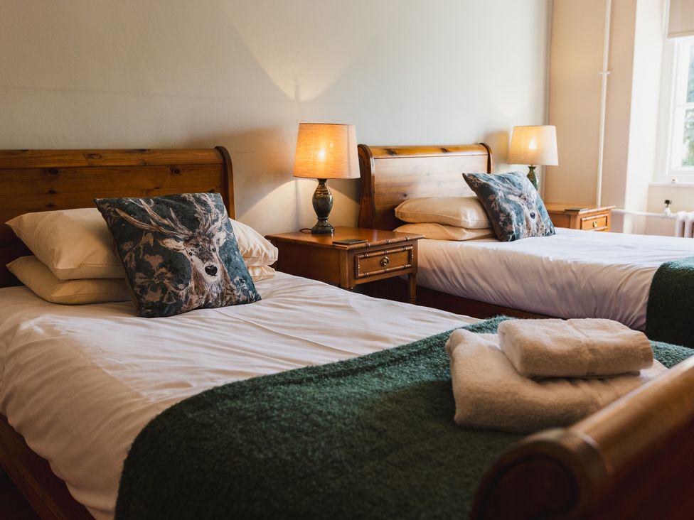 A bedroom with two beds and a nightstand at Cheviot Manor in Akeld near Wooler