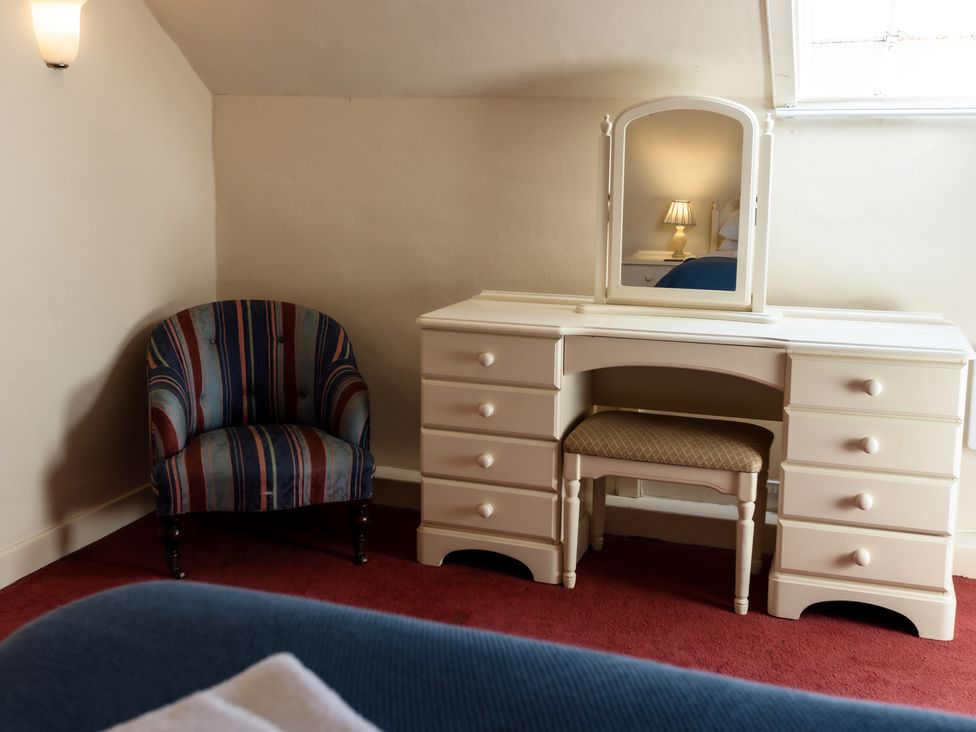 A bedroom with a dressing table and a chair at Cheviot Manor near Wooler
