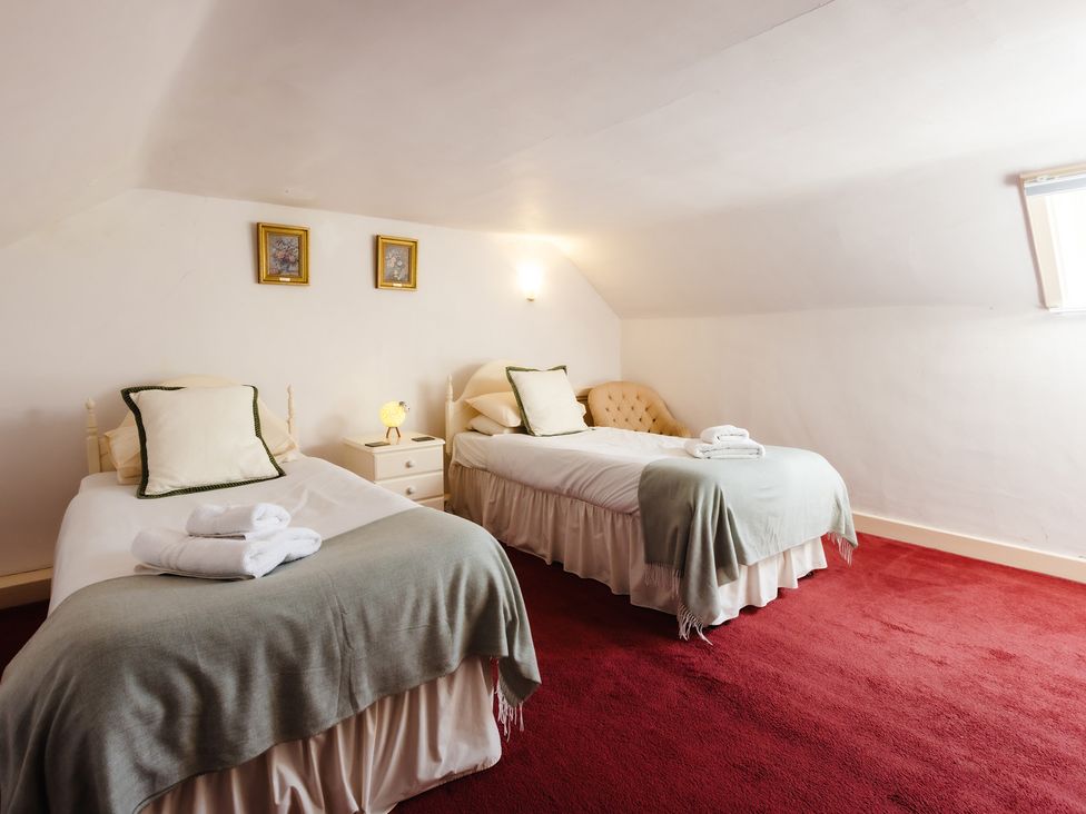 A bedroom with two beds and a bedside table at Cheviot Manor in Akeld near Wooler