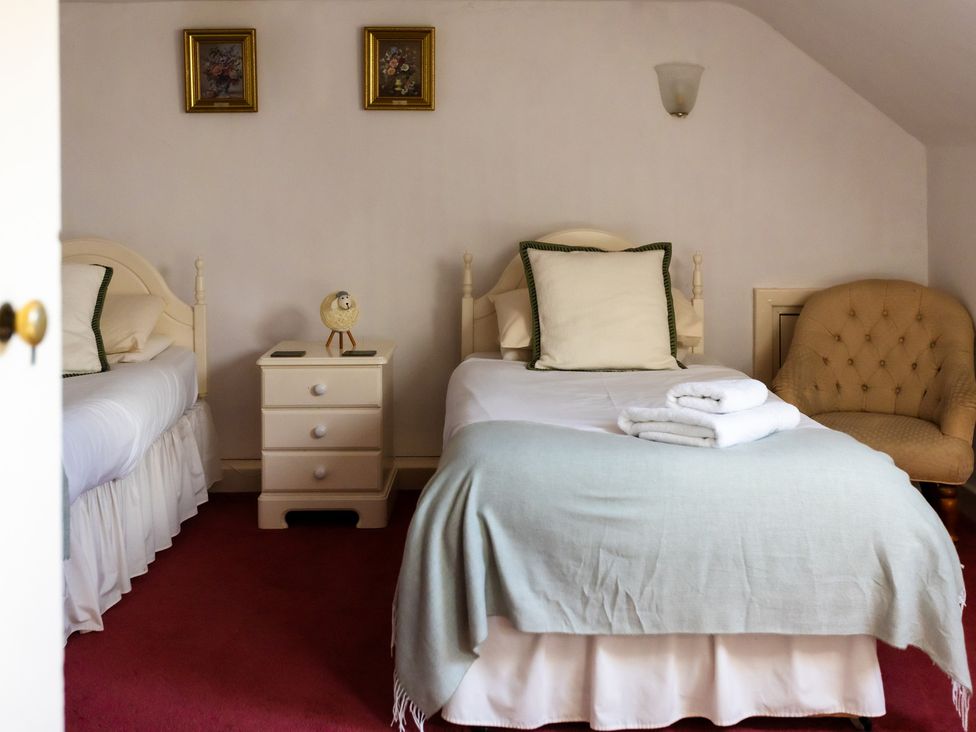 A bedroom with two beds and a nightstand at Cheviot Manor in Akeld near Wooler
