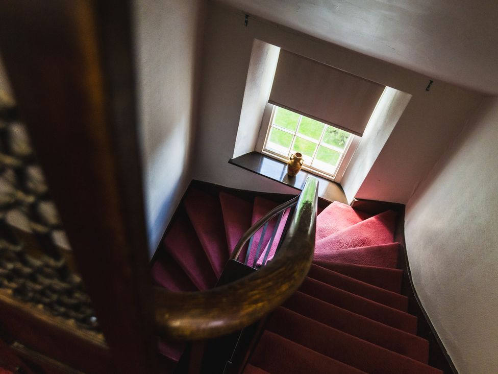 A staircase with a handrail and a window at Cheviot Manor in Akeld near Wooler