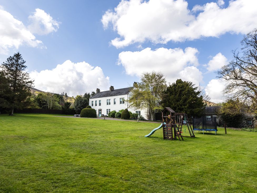 An outdoor area with a house and playground equipment at Cheviot Manor Akeld near Wooler