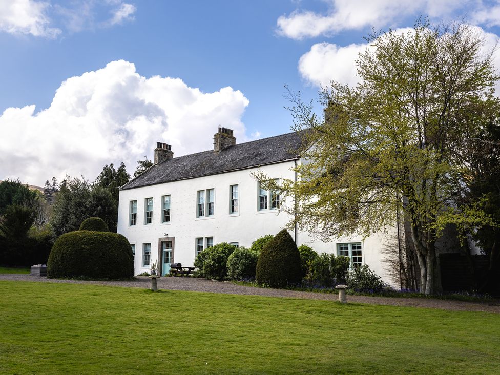 A house with trees and bushes in the garden at Cheviot Manor Akeld near Wooler