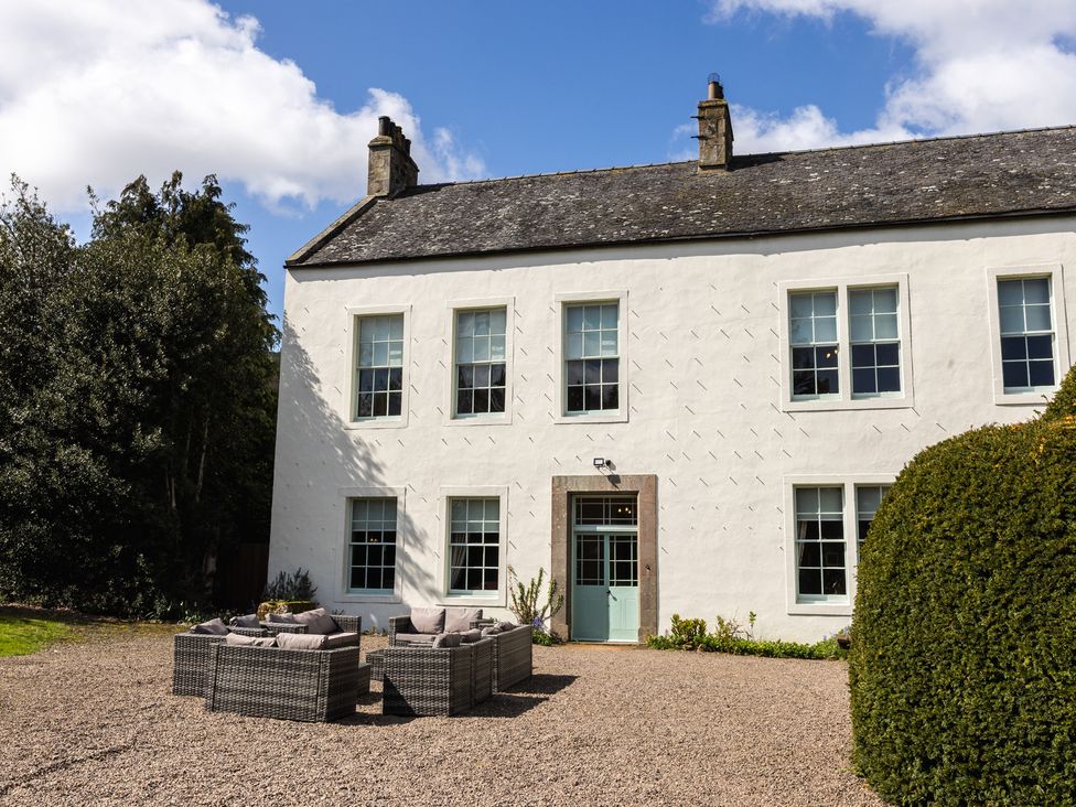 A house with garden seating in front at Cheviot Manor in Akeld near Wooler