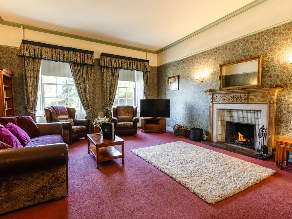 A living room with a fireplace and sofa at Cheviot Manor Akeld near Wooler