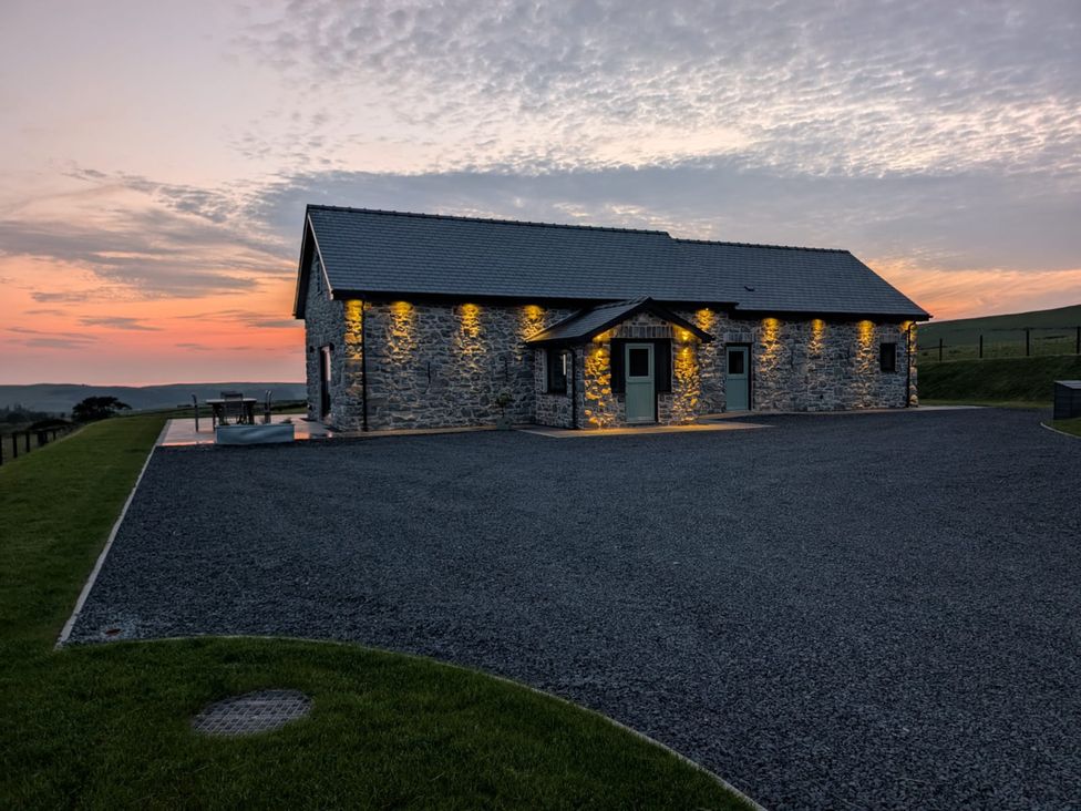 A house with stone exterior and gravel driveway at Golygfa Cwrt in Talybont