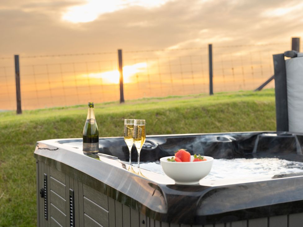 A hot tub with champagne and fruit at Golygfa Cwrt in Talybont