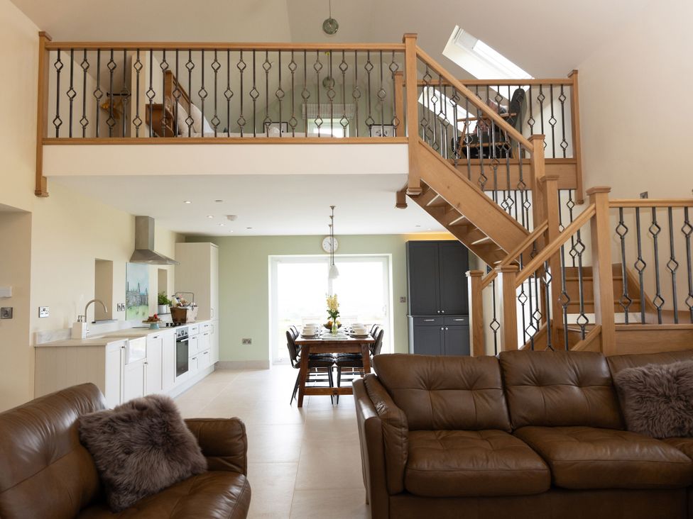 A living room with a staircase and dining area at Golygfa Cwrt, Talybont