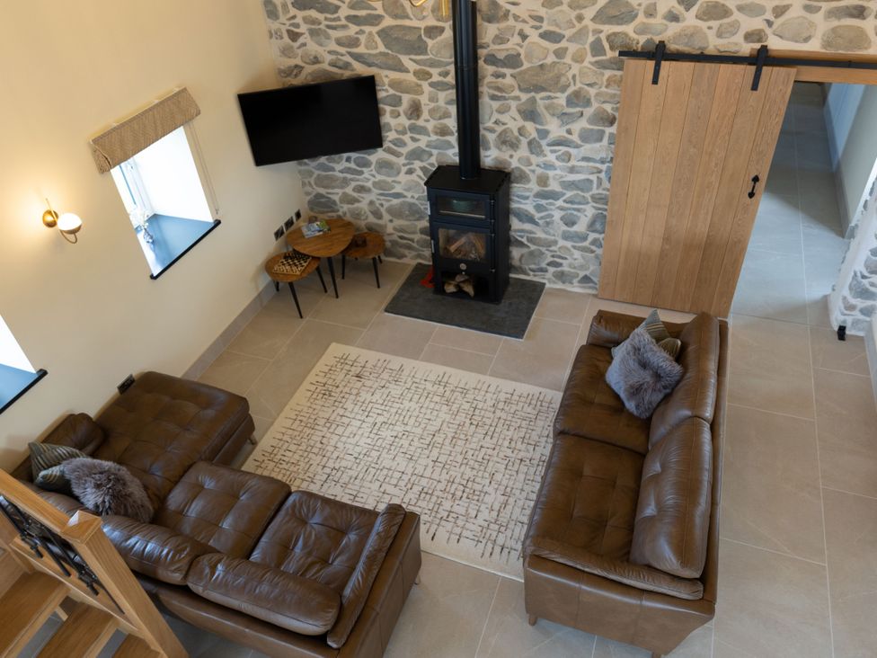 A living room with a fireplace and sofas at Golygfa Cwrt in Talybont