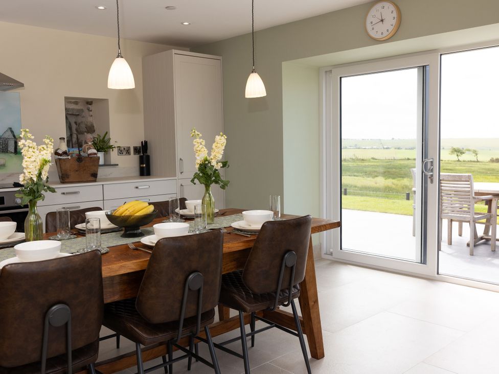 A kitchen with a dining table and chairs at Golygfa Cwrt Talybont
