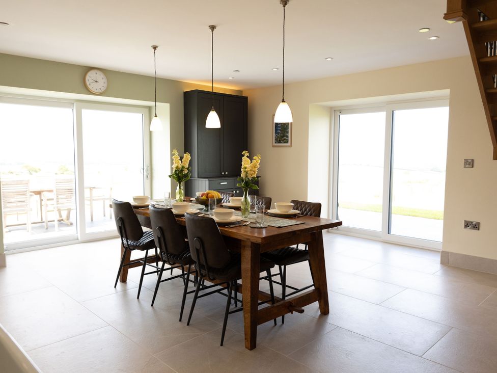 A dining room with a table and chairs at Golygfa Cwrt in Talybont