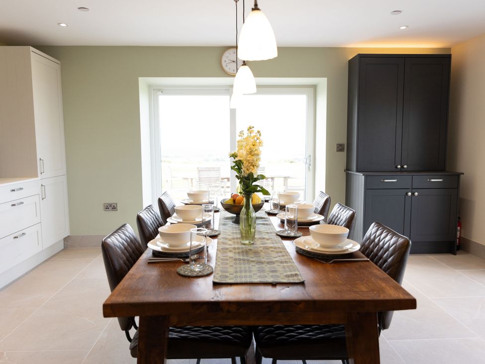 A dining room with a table set for meals at Golygfa Cwrt in Talybont