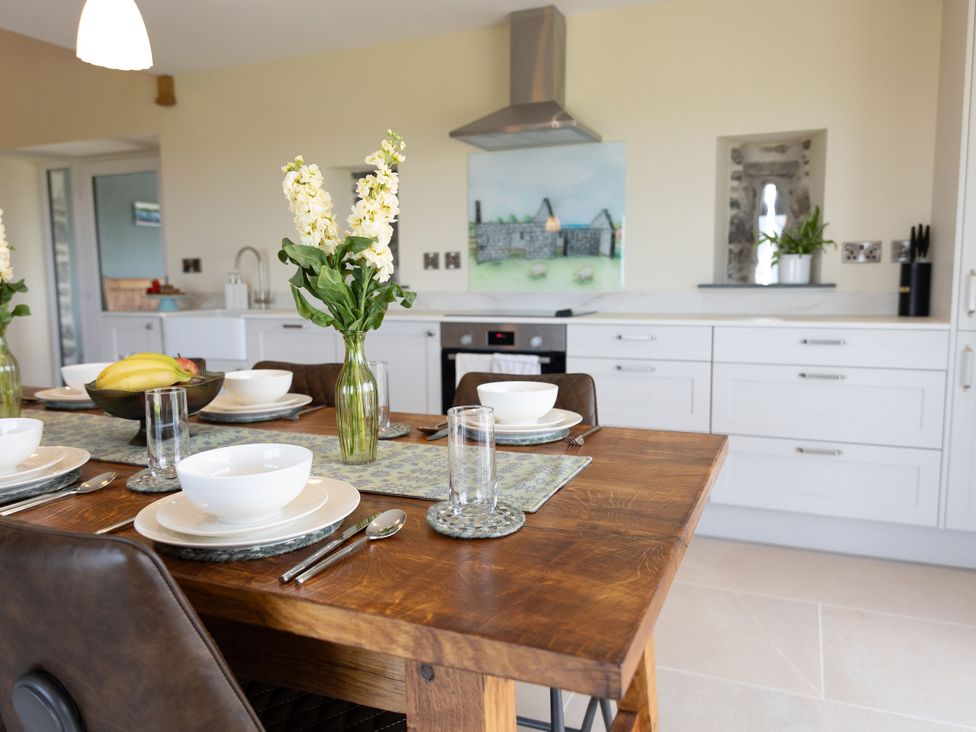 A kitchen with a dining table set for a meal at Golygfa Cwrt in Talybont