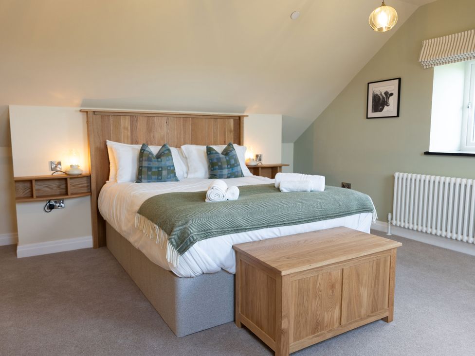 A bedroom with a bed and bedside table at Golygfa Cwrt in Talybont