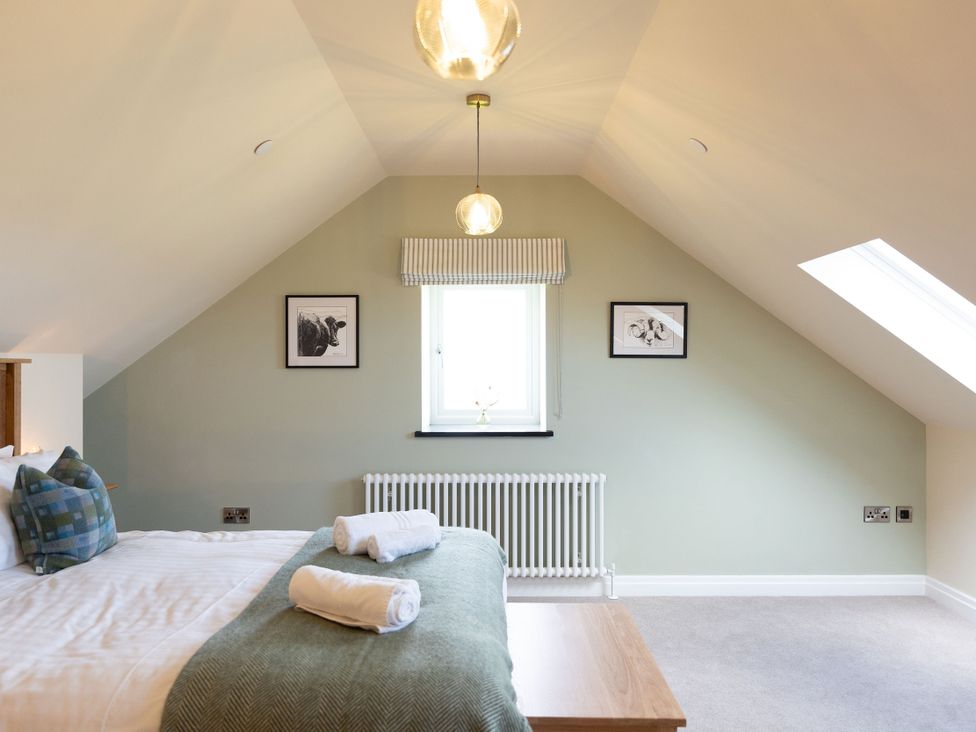 A bedroom with a bed, window, and pictures at Golygfa Cwrt Talybont