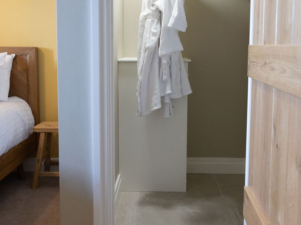 A bedroom with a bed and a robe hanging at Golygfa Cwrt in Talybont