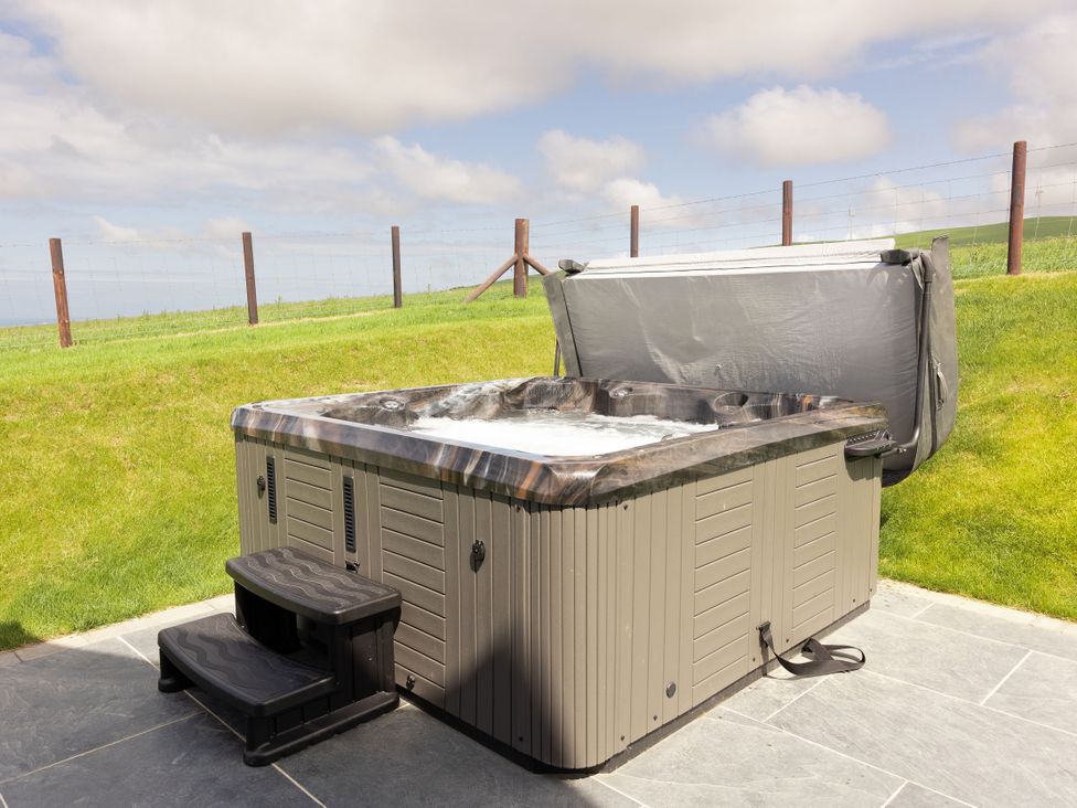 A hot tub with steps and a cover in an outdoor area at Golygfa Cwrt Talybont