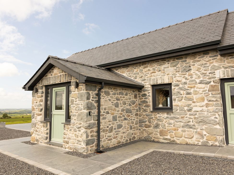 A stone house exterior with an entrance door and window at Golygfa Cwrt in Talybont