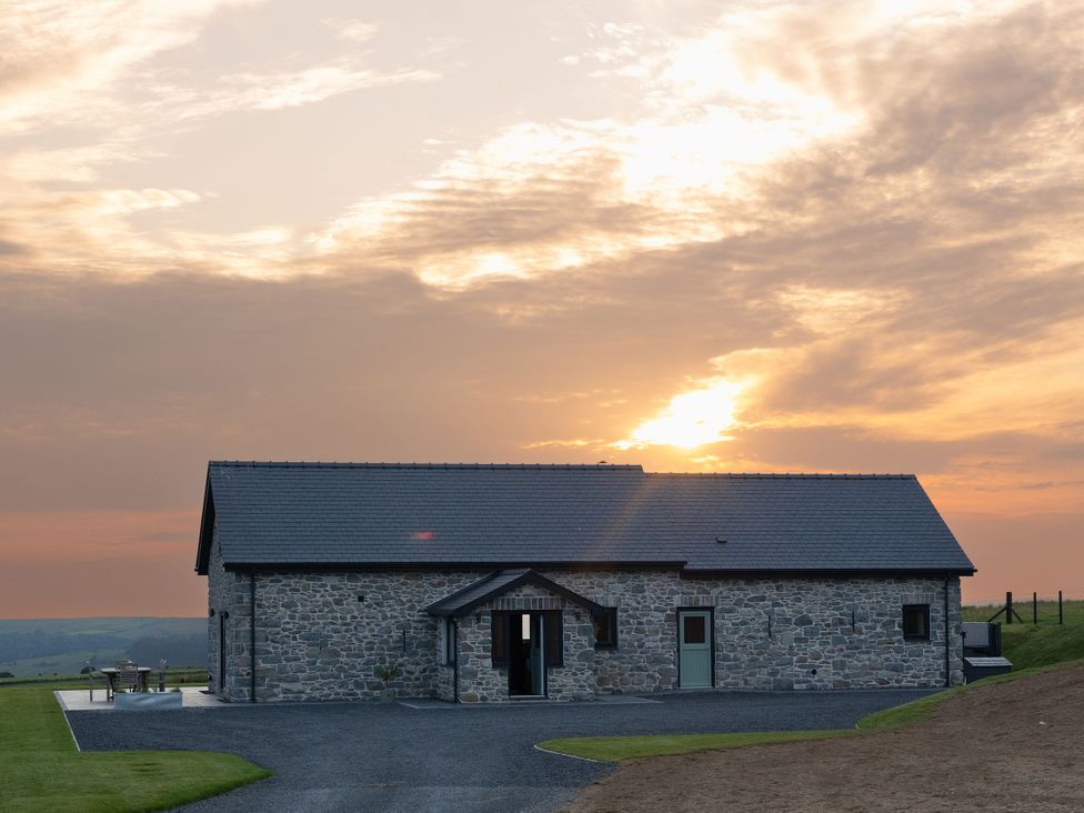 A stone house with a patio at Golygfa Cwrt in Talybont