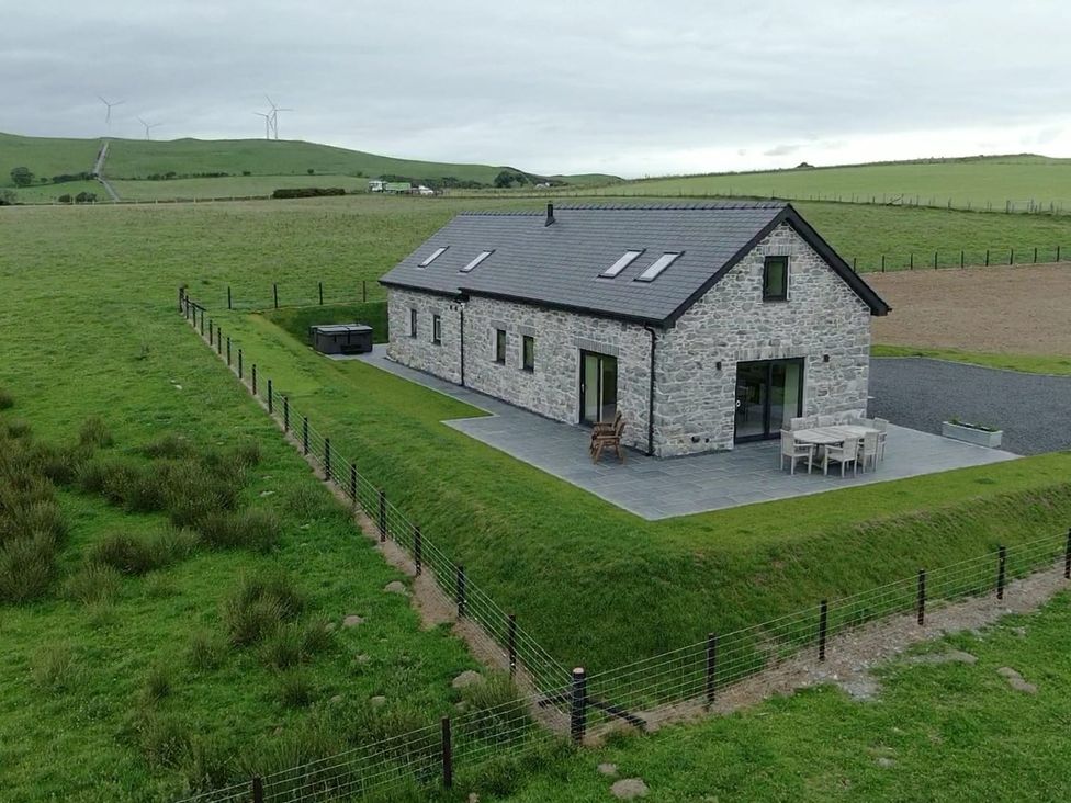 A house with a patio and furniture in an outdoor area at Golygfa Cwrt in Talybont