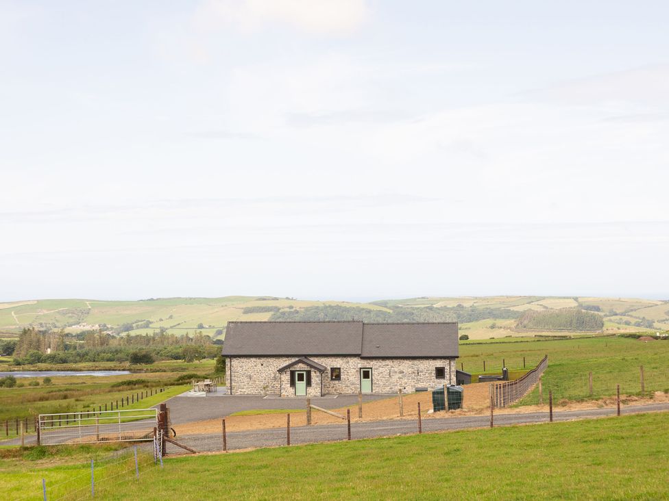 A stone house with a fence and gravel path at Golygfa Cwrt near Bontgoch and Penrhyncoch