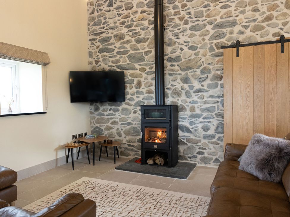 A living room with a fireplace and television at Golygfa Cwrt near Bontgoch and Penrhyncoch