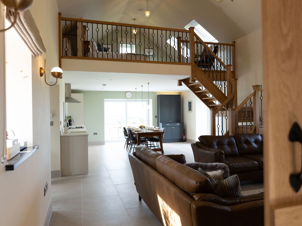 A living room with a sofa and dining area at Golygfa Cwrt Near Bontgoch and Penrhyncoch