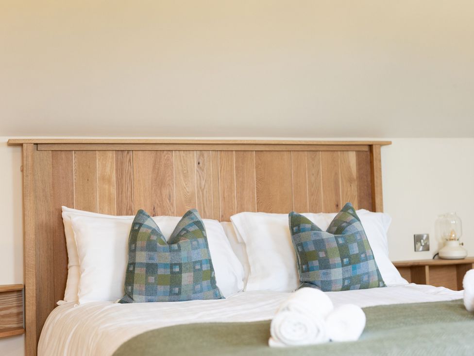 A bedroom with a bed and pillows at Golygfa Cwrt near Bontgoch and Penrhyncoch