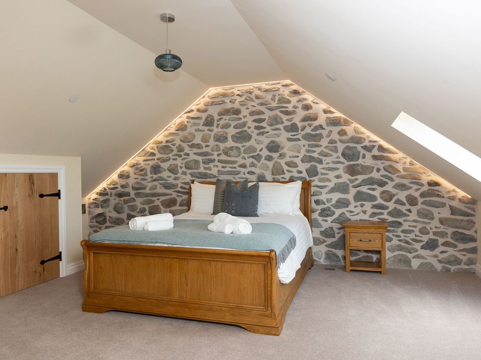 A bedroom with a bed and nightstand at Golygfa Cwrt near Bontgoch and Penrhyncoch