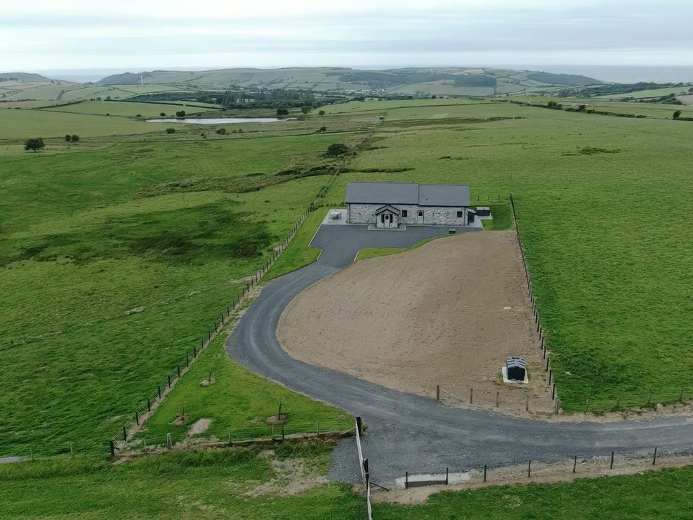 A house with a driveway and fenced area in a grassy field at Golygfa Cwrt Near Bontgoch and Penrhyncoch