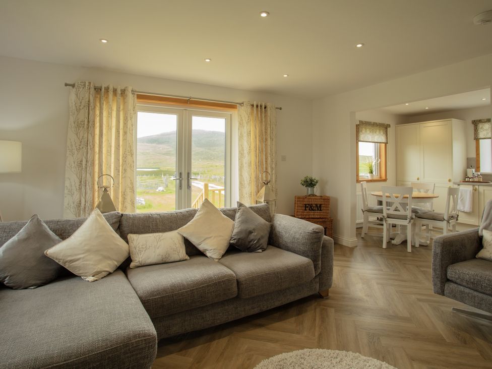 A living room with a sofa and dining area at Taigh Eva near Lochmaddy
