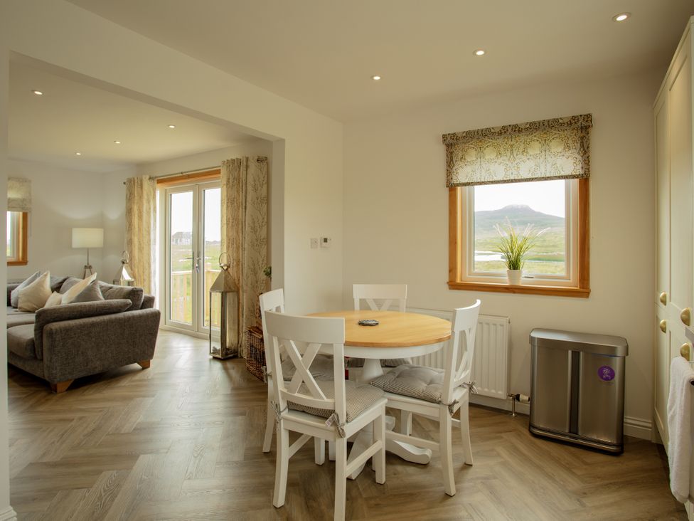 A dining room with a table and chairs at Taigh Eva near Lochmaddy