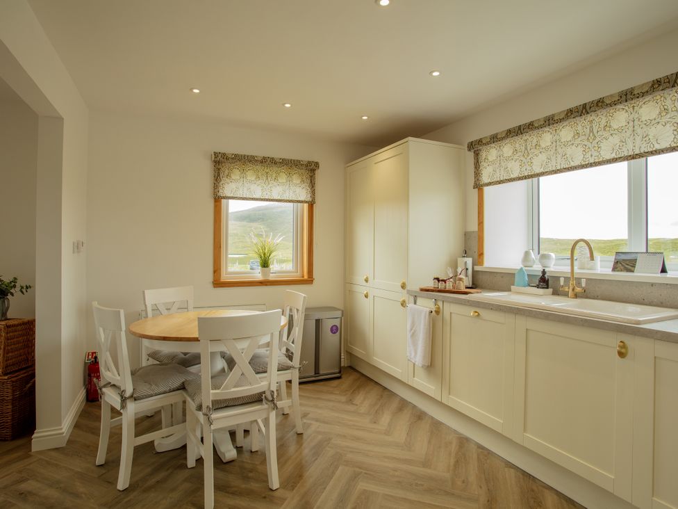 A kitchen with a round table and chairs at Taigh Eva near Lochmaddy