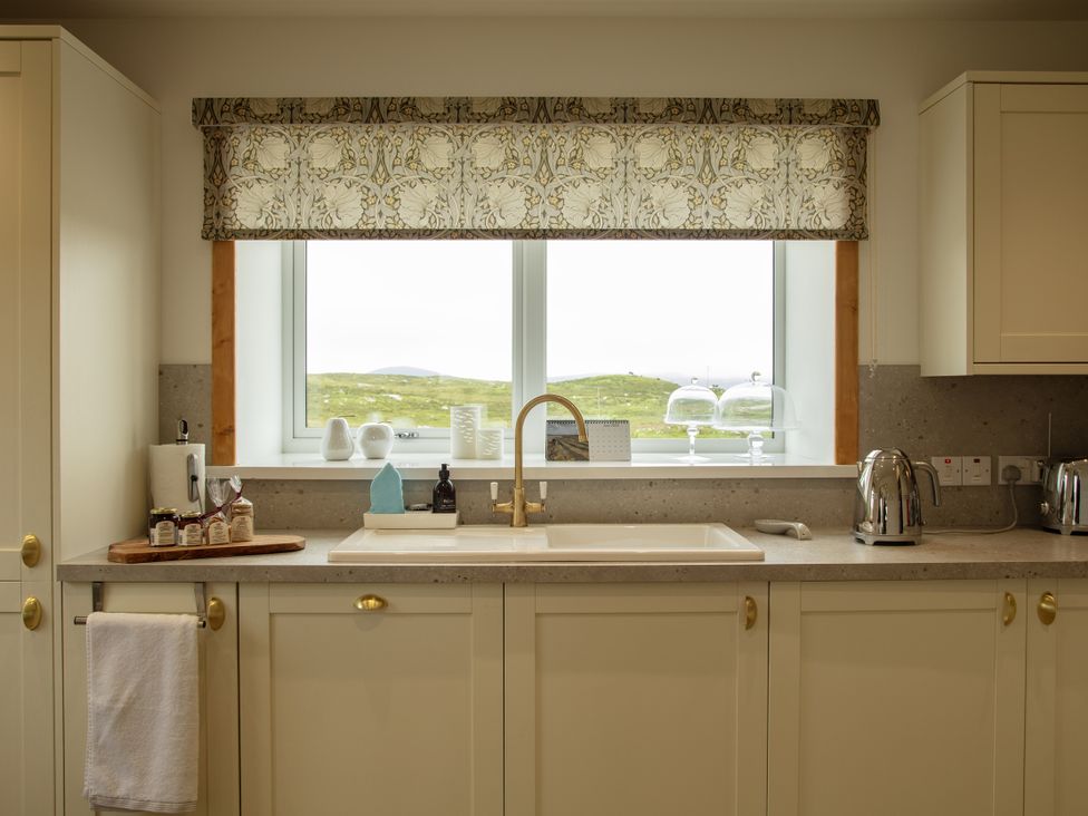 A kitchen with a sink and window at Taigh Eva near Lochmaddy