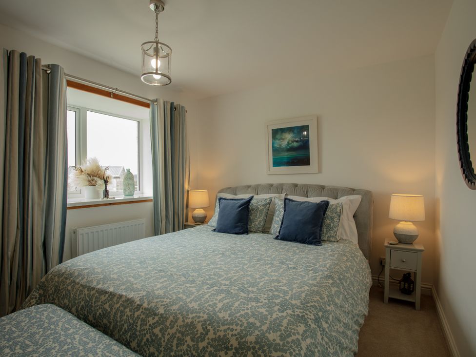 A bedroom with a bed and nightstand at Taigh Eva near Lochmaddy