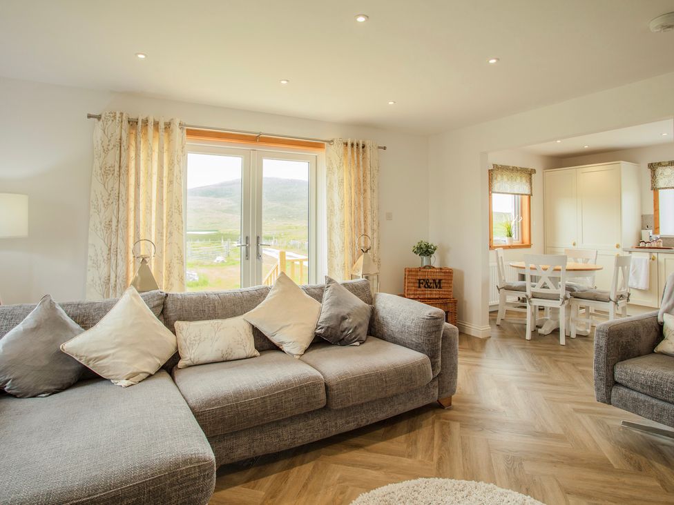 A living room with a sofa and dining area at Taigh Eva near Lochmaddy